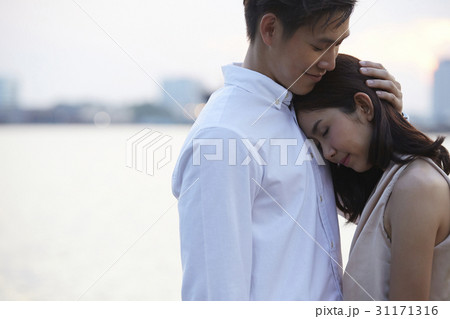 a man is hugging his girlfriend. 31171316