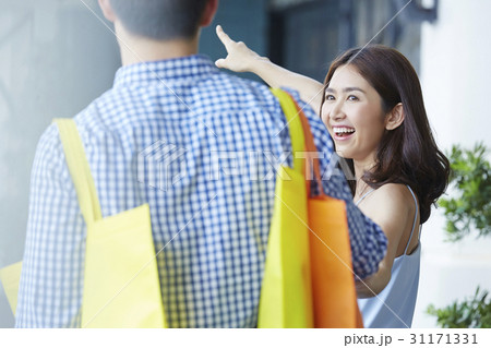 a woman is smiling and pointing her boyfriend something. 31171331