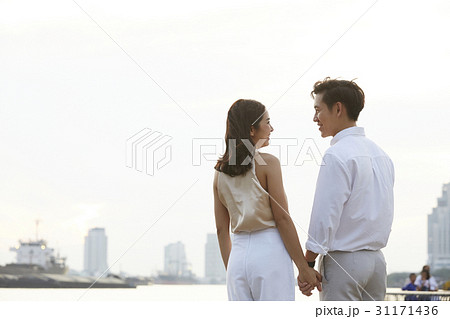 Rear view of a couple holding hands, looking at each other. Rear view of a couple holding hands, looking at each other. 31171436