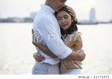A man and woman are hugging at the riverside. A man and woman are hugging at the riverside. 31171452