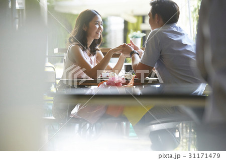 The couple is holding hands and smiling in café. The couple is holding hands and smiling in café. 31171479