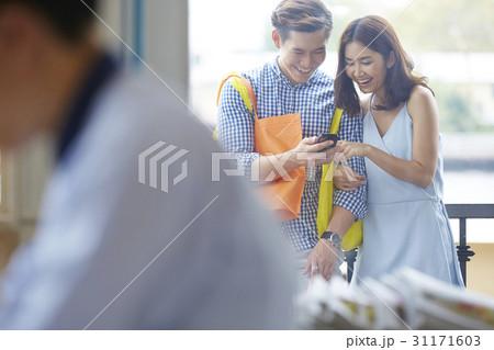 Young couple is smiling when reading looking at the mobilephone 31171603