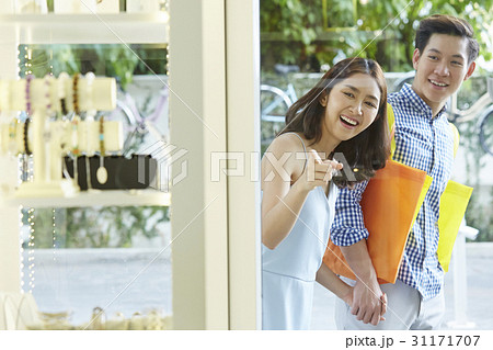 A girl is excited and pointing to items in a store for a happy man 31171707