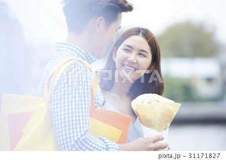 A woman is looking her boyfriend holding a crepe. A woman is looking her boyfriend holding a crepe. 31171827