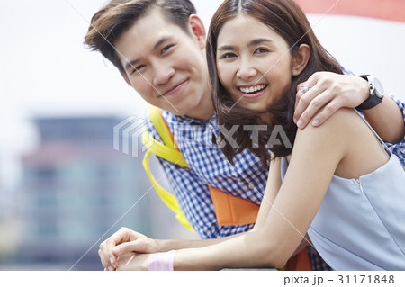 A man's arm is on a woman's shoulder and they are smiling. 31171848