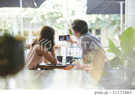 A couple is taking selfie by smartphone at a café. 31171864