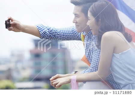 A couple is taking selfie outdoors together. 31171880