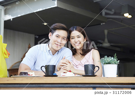 A photo of a couple sitting with arm in arm in the coffee shop A photo of a couple sitting with arm in arm in the coffee shop 31172006
