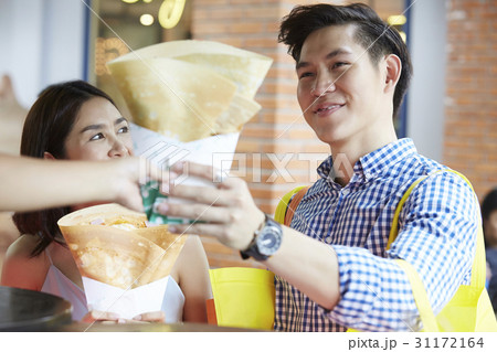 a man and woman are happily taking food from someone a man and woman are happily taking food from someone 31172164