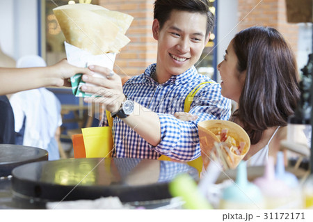 man and woman are smiling, buying food and looking at each other man and woman are smiling, buying food and looking at each other 31172171