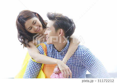 a photo of a man carrying a woman on his back and smiling 31172212