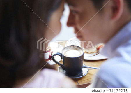 a cup is in front of a couple with face closing to face 31172253