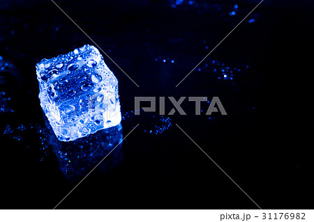 Blue ice cubes on black wet table. 31176982