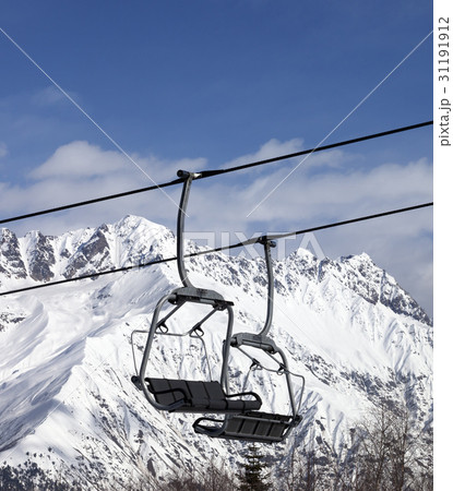 Chair lift in snowy mountains at nice sun day 31191912