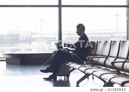 空港で飛行機の待ち時間に仕事をするビジネスマン 31192042