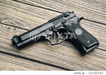 Handgun, 9mm pistol close-up on wooden background. 31192432