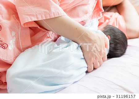 生後間もない赤ちゃんと授乳する母親　ママ　生まれたて乳児　産婦人科　個室　ベイビー　ベビー　ぼかし 31196157