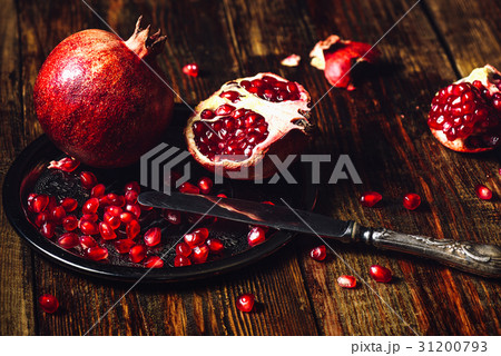 Whole and Opened Pomegranates on Metal Plate. Whole and Opened Pomegranates on Metal Plate. 31200793