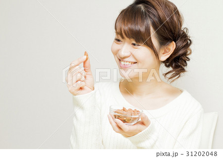 アーモンドを食べる女性 31202048