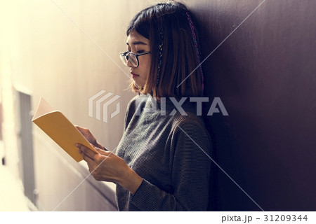 Girl with Glasses Standing Reading Book 31209344