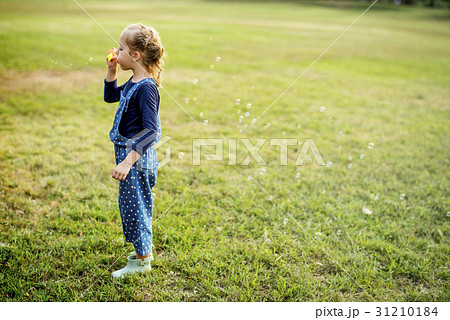 Little Girl Blowing Bubble at Grass Field Park Outdoor 31210184