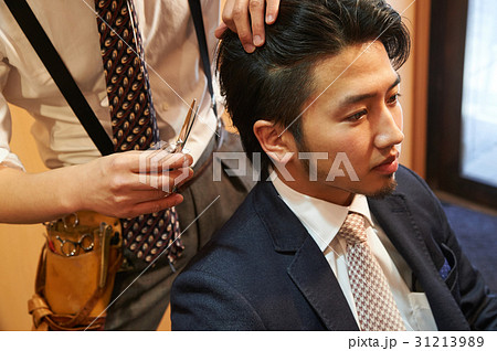 理容師とスタイリングを相談する男性客 31213989