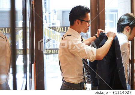 ジャケットをスタイリストに預ける男性客 31214027