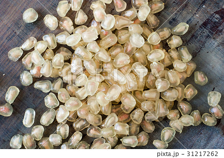 white pomegranate seeds on wooden table 31217262