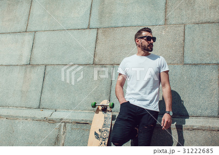 Stylish man in sunglasses and with a beard stands 31222685