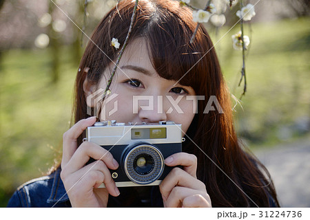カメラ女子 カメラ 一眼レフ レトロ 女性 20代 桜 目線 花 ロング 長髪 かわいい の写真素材 31224736 Pixta