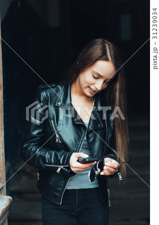 Beautiful girl in black jacket with smartphone 31239034