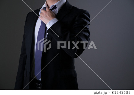 ビジネスマン スーツ ネクタイ 緩めるの写真素材