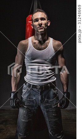 Photo of aggressive man and red boxing bag 31248669
