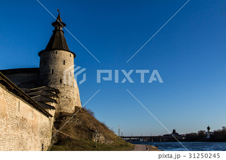 Fortress wall and a tower on the river bank. 31250245
