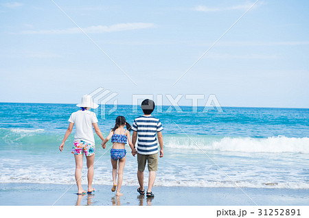夏休みに海で遊ぶ家族 後ろ姿の写真素材