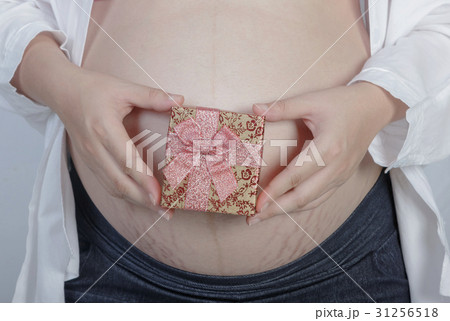 pregnant woman holding a gift box 31256518
