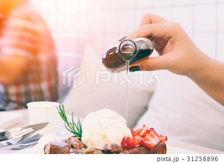 Close up woman pouring honey on honey toast. 31258896