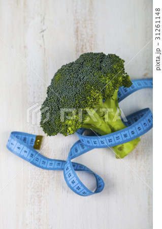Broccoli and measuring tape on a table close-up. 31261148