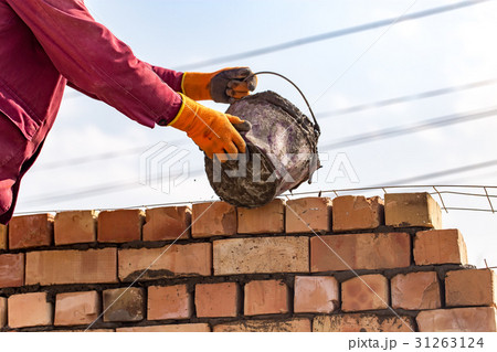 Worker builds a brick wall in the house Worker builds a brick wall in the house 31263124