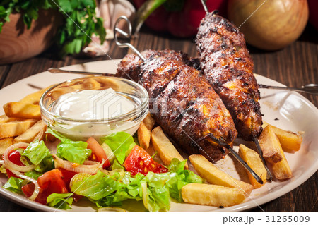 Grilled shish kebab served with fried chips 31265009