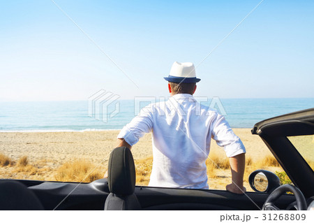 Man on summer beach near car looking to the sea Man on summer beach near car looking to the sea 31268809