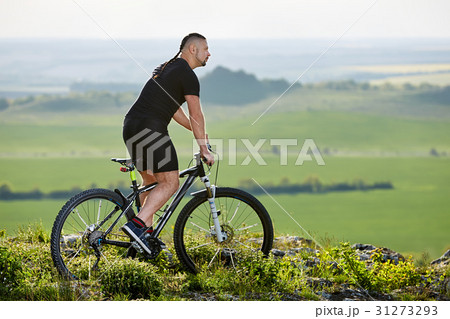 Cyclist standing with mountain bike on background Cyclist standing with mountain bike on background 31273293