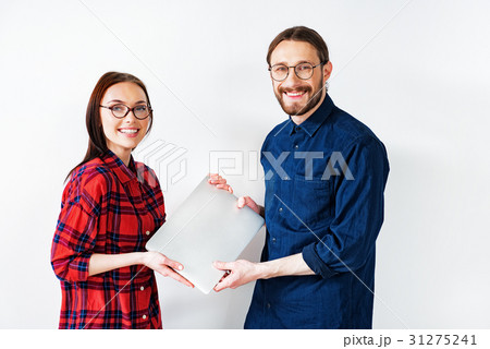 Cheerful smart couple presenting modern technology Cheerful smart couple presenting modern technology 31275241