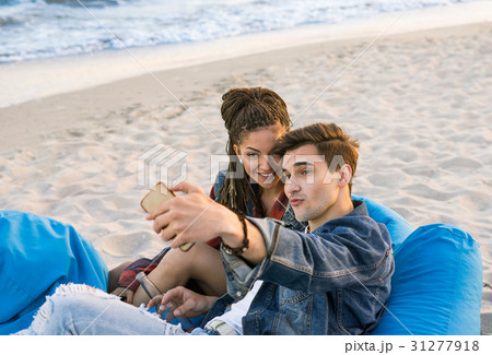 young couple taking selfie photo at the beach 31277918