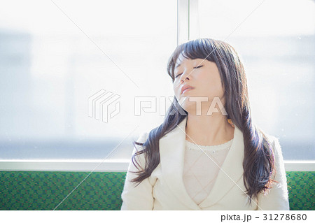 電車で居眠りする女性の写真素材