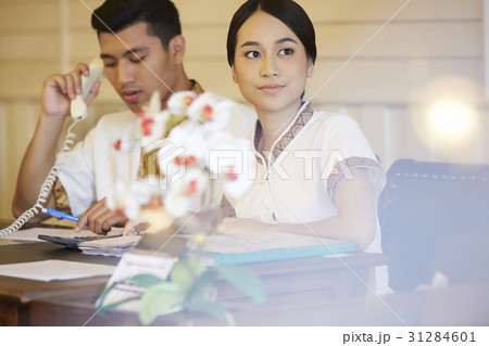 the receptionist is looking outside and waiting guests. 31284601