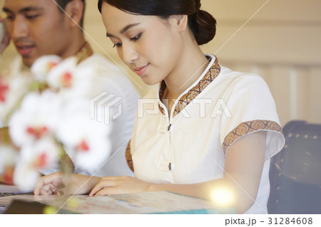 a portrait of a beautiful receptionist reading guest book. 31284608