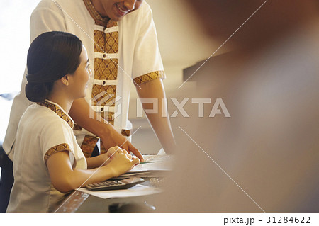 Two staff are discussing happily about the document on the table 31284622