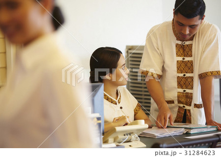a receptionist is guiding his female colleague. a receptionist is guiding his female colleague. 31284623