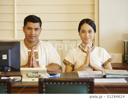 a portrait of two receptionists welcoming guests by Thai style. a portrait of two receptionists welcoming guests by Thai style. 31284624